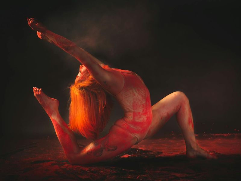 Person performing a flowing yoga sequence against dark wall
